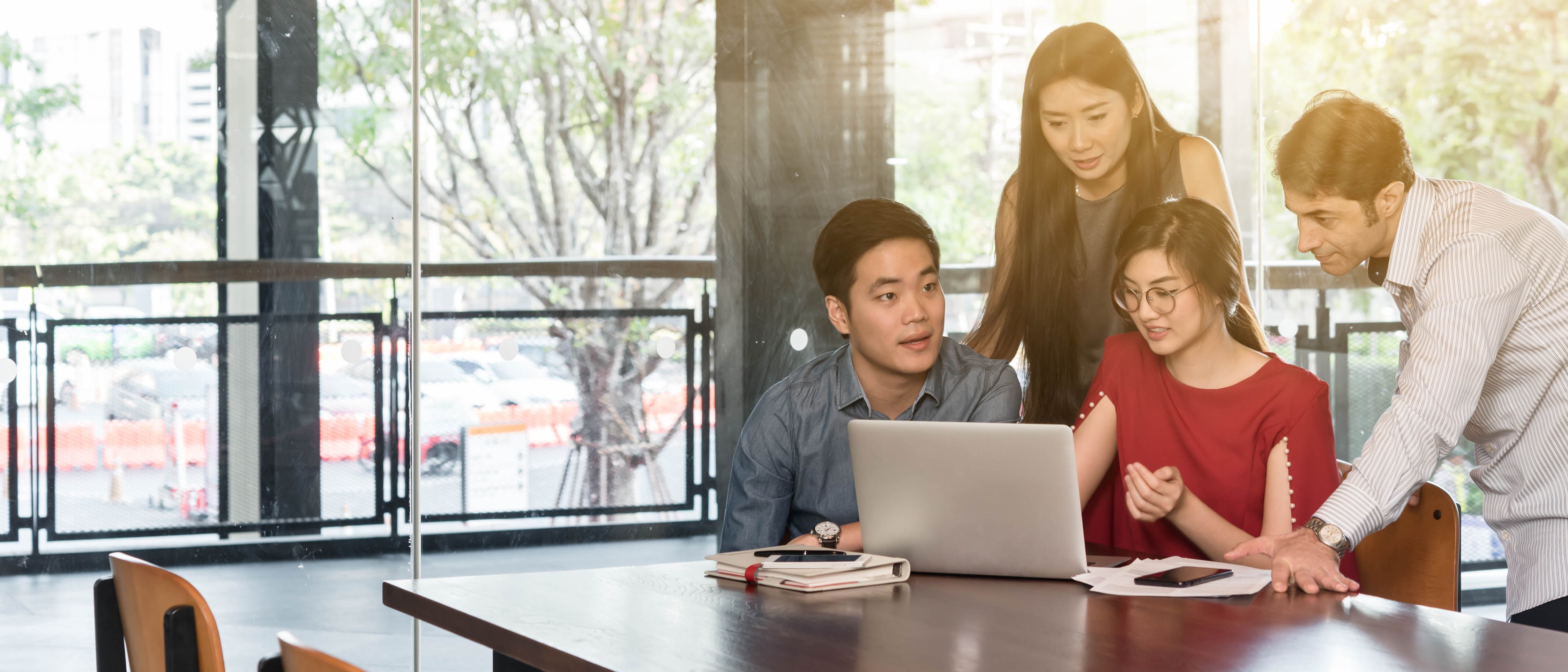 Four individuals in a group discussion indoors